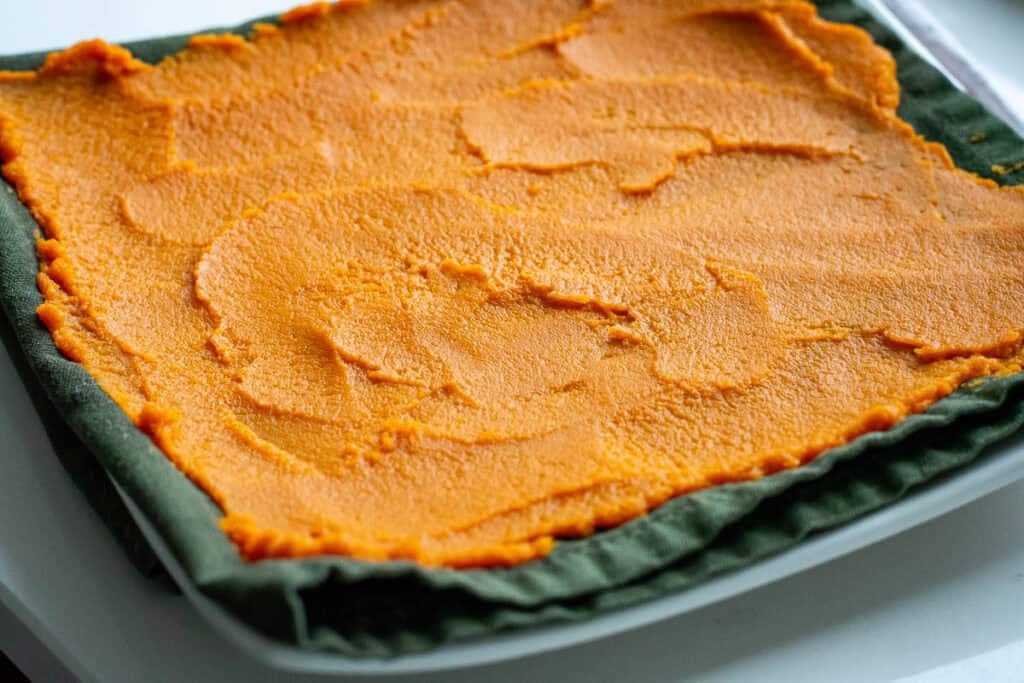 Pumpkin puree spread on a clean cloth in a thin layer.