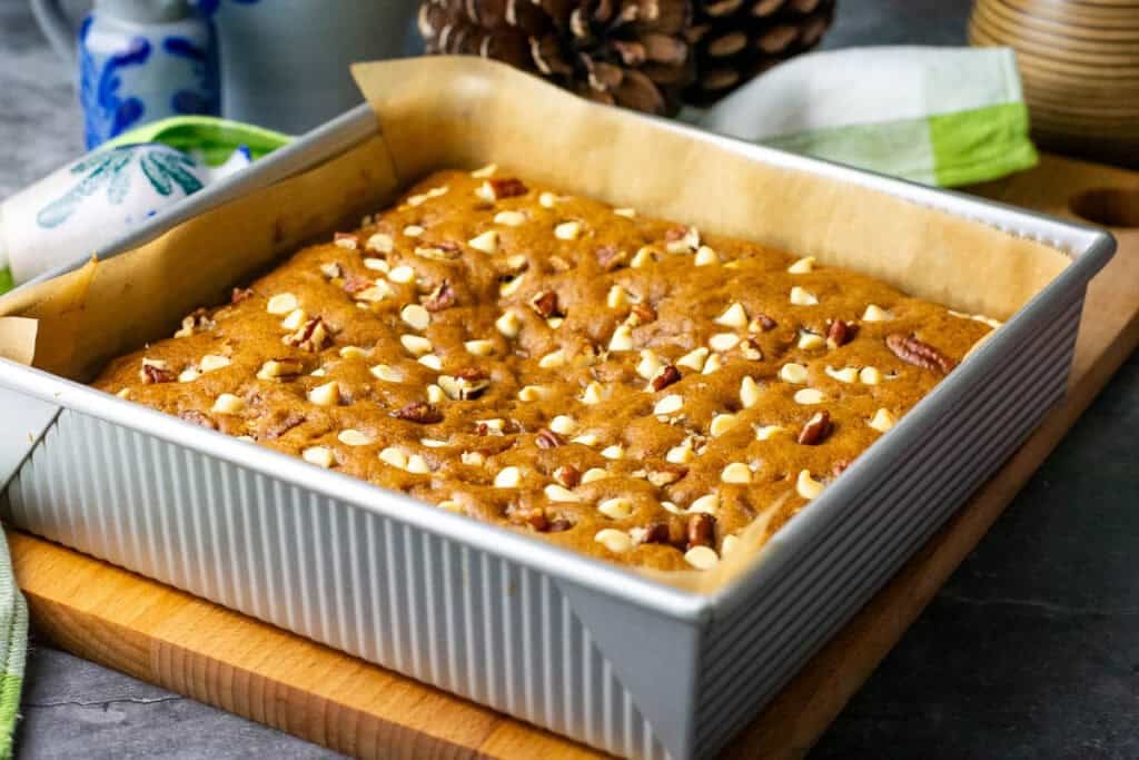 Baked sourdough pumpkin blondies cooling in a baking pan.