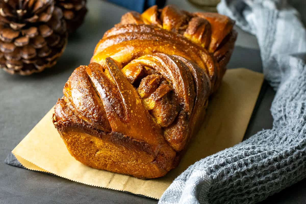Pumpkin Sourdough Babka on a piece of parchment paper ready to slice.