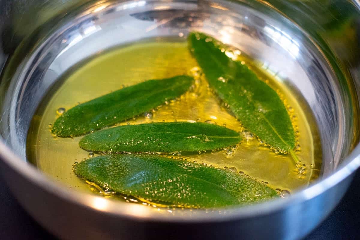 Sage leaves frying in hot oil.