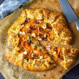 Butternut Squash Sourdough Galette with one slice cut on a piece of parchment paper.