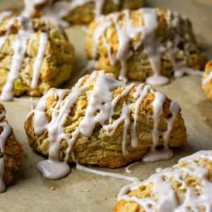 Cinnamon sugar glazed sourdough apple scones on a baking sheet lined with parchment paper.